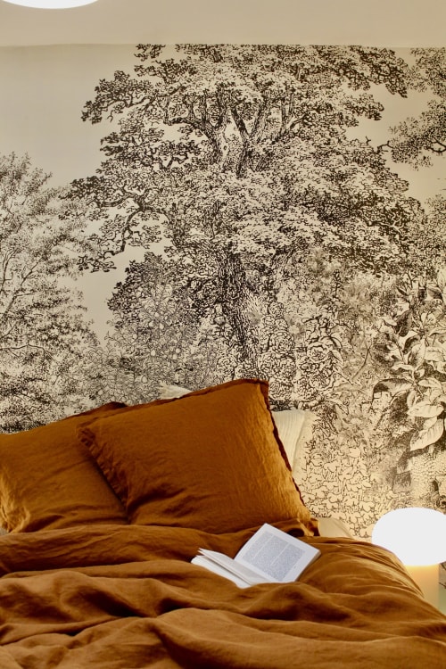 Lit douillet avec coussins moutarde et livre ouvert sur papier peint botanique à la Suite Arigato, Mi Casa Es Su Casa, Carcassonne