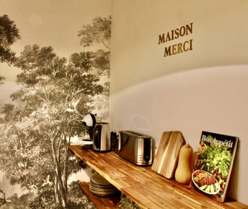 Suite de l'hôtel Mi Casa Es Su Casa à Carcassonne avec fresque murale, étagère en bois, bouilloire et magazine Bon Appétit