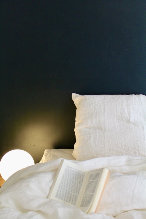 Lit douillet avec oreillers blancs et un livre ouvert dans la Suite Thanks de l'hôtel Mi Casa Es Su Casa, Carcassonne