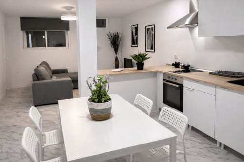 Cuisine ouverte moderne et salle à manger de l'appartement El Jardín à Icod de los Vinos avec table blanche et vue sur le salon