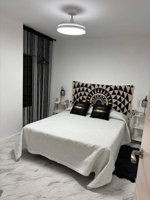 Chambre moderne à Casonas de Marengo avec lit blanc, tête de lit géométrique, rideaux noirs et sol en marbre