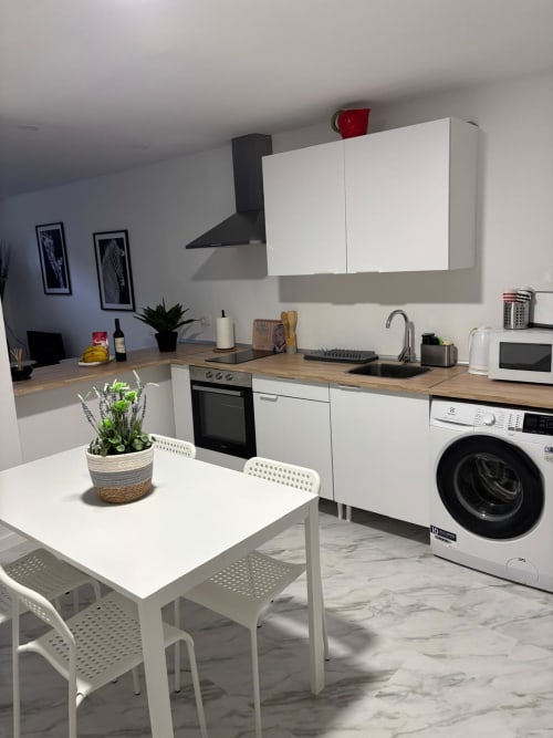 Cuisine moderne de l'appartement El Jardín aux Casonas de Marengo, Icod de los Vinos avec armoires blanches et plan de travail en bois