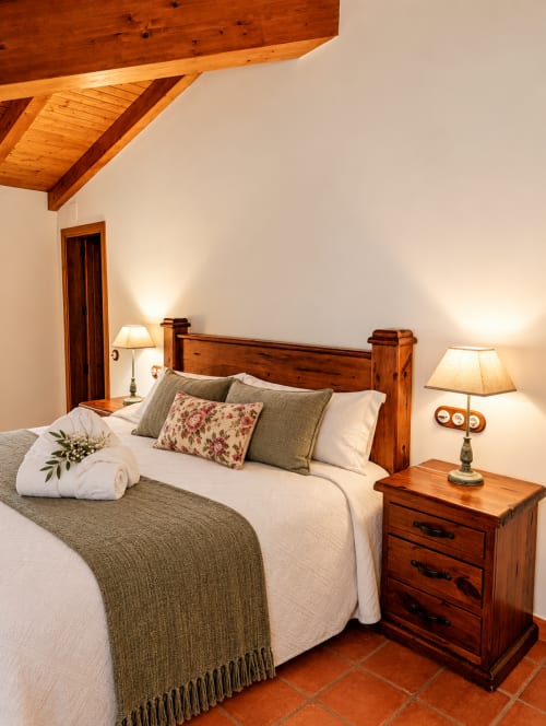 Habitación boutique en El descanso del peregrino B&B de Guadalupe con vigas de madera, muebles rústicos y tonos de terracota