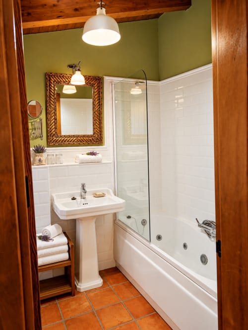 Baño moderno del hotel boutique El descanso del peregrino en Guadalupe, Cáceres con lavabo de pedestal y bañera de hidromasaje