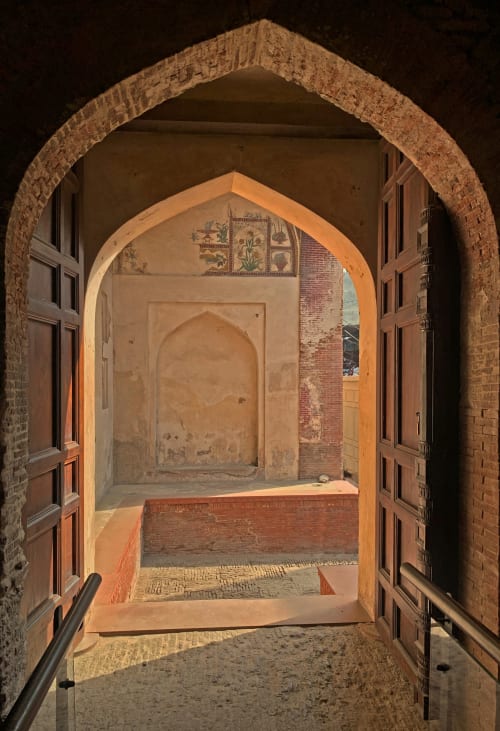 Portail voûté traditionnel de l'hôtel Eucalyptus Ethnic à El Ghazouane, Maroc, orné de portes en bois travaillé et de carrelage décoratif