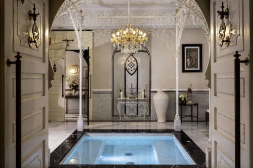 Salle de bains spa luxueuse à l'hôtel Eucalyptus Ethnic à El Ghazouane avec baignoire, lustre et finitions en marbre ouvragé.