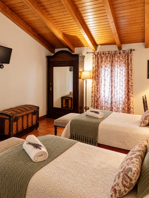 Habitación boutique en El descanso del peregrino en Guadalupe con vigas de madera, camas gemelas y decoración tradicional