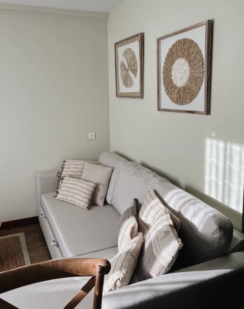 Acogedora habitación en Alojamientos Montaña Leonesa con ropa de cama clara, almohadas rayadas y cuadros de arte natural en las paredes