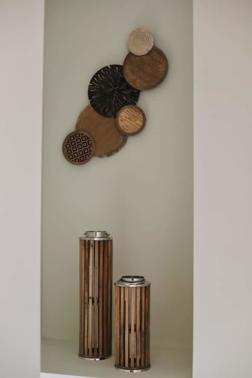 Decoración de pared de madera con cestas circulares y jarrones rayados en apartamento de refugio de montaña