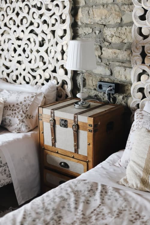 Habitación en Alojamientos Montaña Leonesa con mesita de noche vintage, cabecero decorativo y lámpara