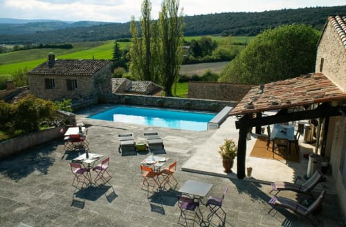 Espace piscine du Clos des Amandiers avec chaises longues, coin repas et vue sur la campagne toscane, chambre d'hôtes française