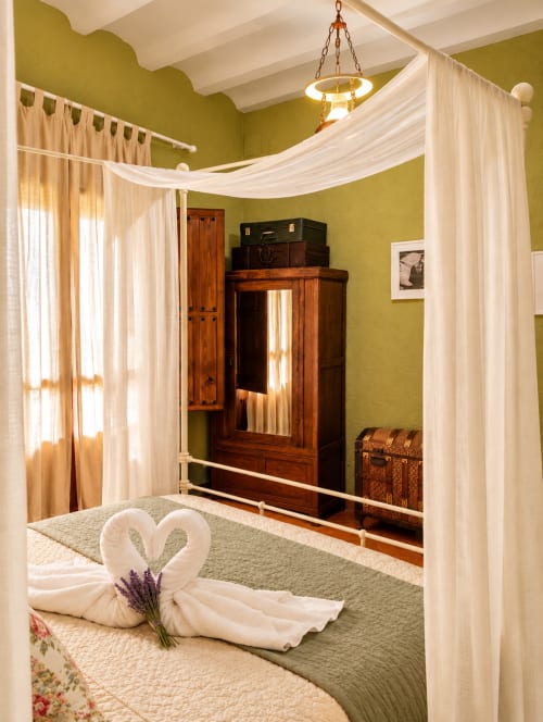 Cama con dosel lujosa y almohadas en forma de corazón en la Habitación Boutique 7 de El descanso del peregrino, Guadalupe