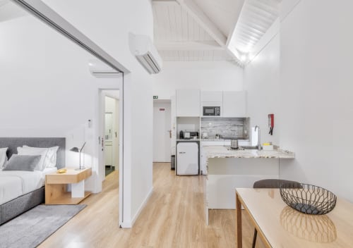 Modern one-bedroom apartment at Oporto Comfort Dom Hugo in Porto with open-plan kitchen, dining area, and bedroom featuring