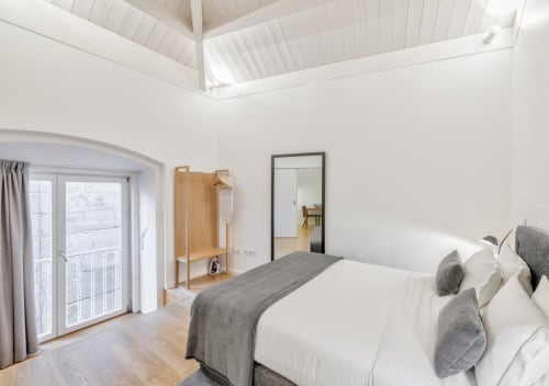 Bright bedroom in Oporto Comfort Dom Hugo apartment with modern bed, wooden wardrobe, and skylight in Porto