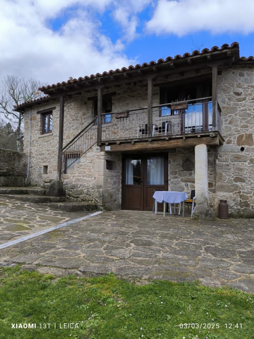 Edificio de apartamentos en piedra con balcón en Bikarte Alojamientos, Sober España, patio interior con mobiliario de jardín