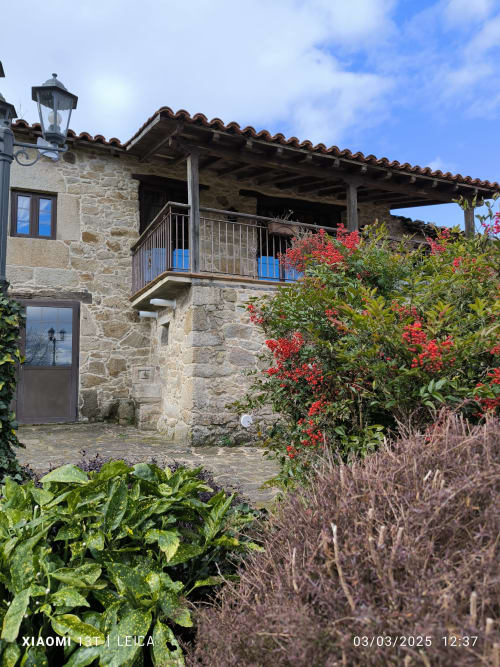 Apartamento casa de piedra Alburiñas en Ribeira Sacra con enredaderas de flores rojas y vistas al jardín, Sober España