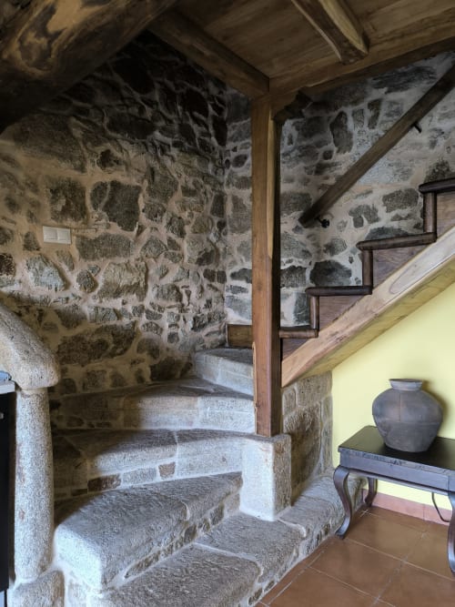 Escalera de piedra con vigas de madera en el apartamento Alburiñas de Bikarte Alojamientos, Ribeira Sacra