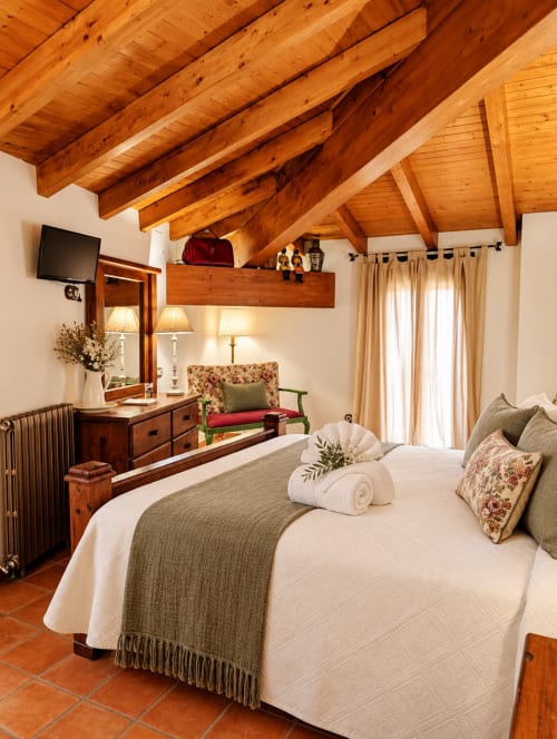 Dormitorio rústico con vigas de madera vista en El descanso del peregrino B&B, Guadalupe, Cáceres