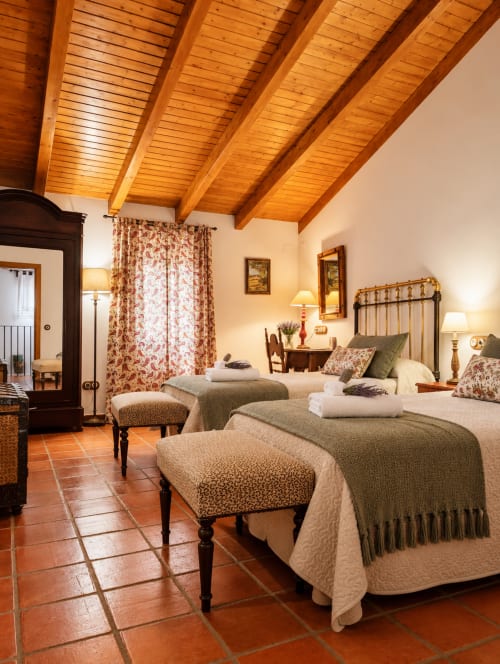 Amplia habitación en El descanso del peregrino de Guadalupe con vigas de madera, azulejos de barro y camas gemelas