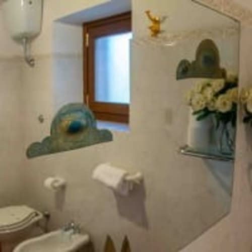 Bagno Belvedere Sopra con toilette, lavandino, finestra e piante di cactus decorative all'Antico Belvedere