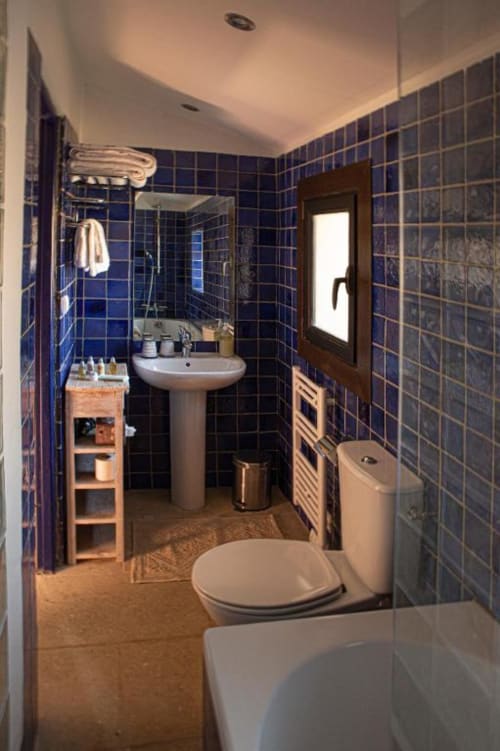 Salle de bain moderne aux carrelages bleu profond, lavabo sur colonne et douche de la Suite Bleuet au Clos des Amandiers, Provence