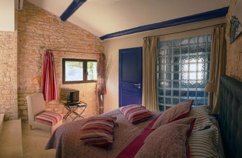 Chambre Bleuet au Clos des Amandiers, Simiane-la-Rotonde avec murs en pierre apparente, poutres bleues et grandes fenêtres
