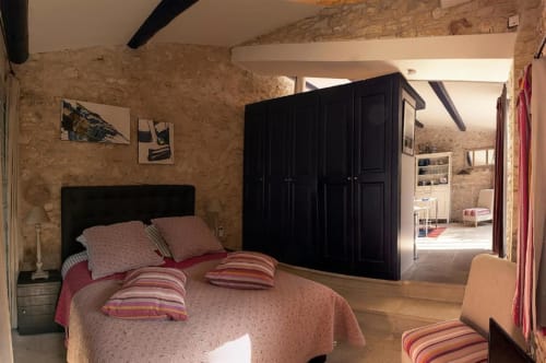 Chambre Bleuet au Clos des Amandiers à Simiane-la-Rotonde avec murs en pierre, armoire noire et literie rayée