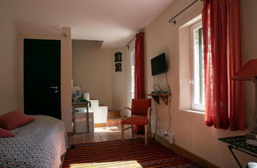 Studio Tournesol au Clos des Amandiers, Simiane-la-Rotonde : appartement lumineux avec accents rouges, lit, fauteuil
