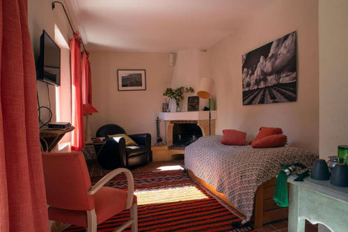 Studio Tournesol au Clos des Amandiers à Simiane-la-Rotonde, chambre lumineuse avec lit, fauteuil et cheminée