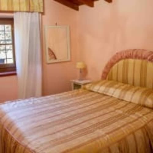Camera Belvedere Sotto dell'Antico Belvedere B&B con letto a righe, pareti color pesca e finestra con tende