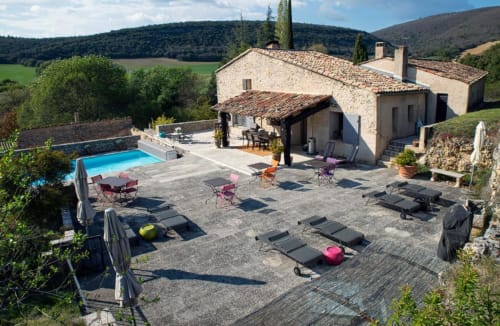 La cour du Clos des Amandiers avec piscine, chaises longues et villa provençale en pierre à Simiane-la-Rotonde