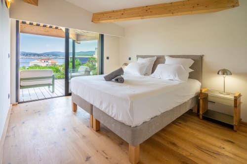 Chambre de luxe avec vue sur mer, poutres en bois, lit king-size et terrasse donnant sur la Méditerranée au Lord Resort