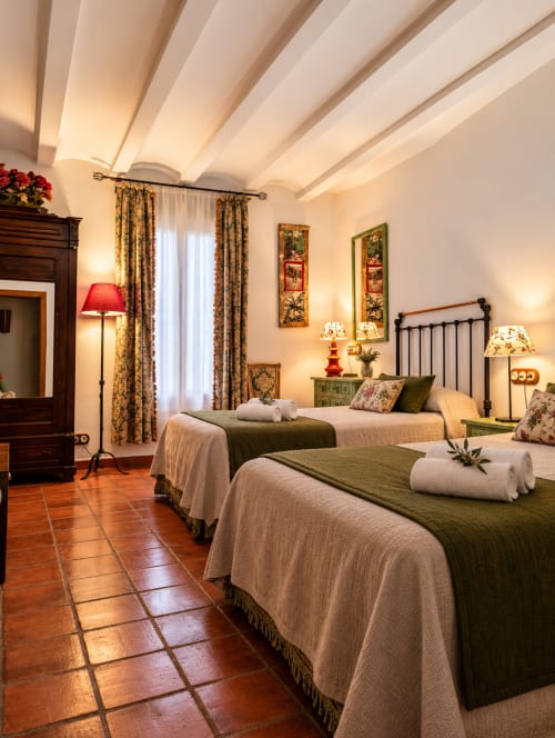 Elegante habitación de villa en El Descanso del Peregrino, Guadalupe, con camas gemelas, vigas de madera vista y vistas a la montaña