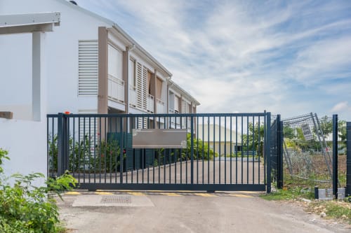 Modern apartment entrance at Vista Del Mar, Sainte-Anne Guadeloupe, with black metal gate and terrace access