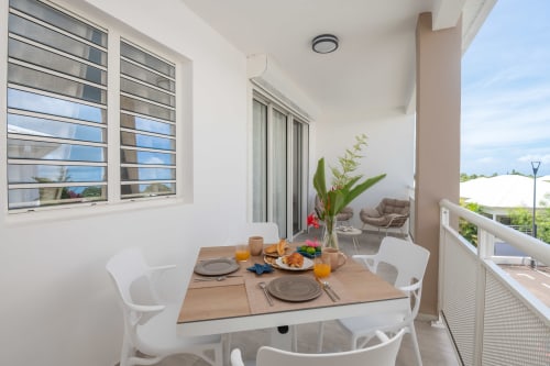 Outdoor dining terrace at Vista Del Mar apartment in Sainte-Anne, Guadeloupe with table set for breakfast