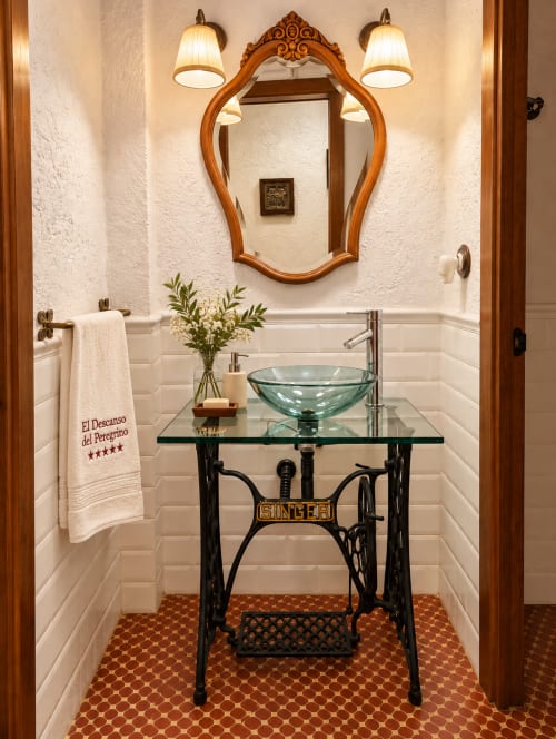Elegante tocador de baño en villa El Descanso del Peregrino en Guadalupe con espejo ornamentado y lavamanos vintage Singer