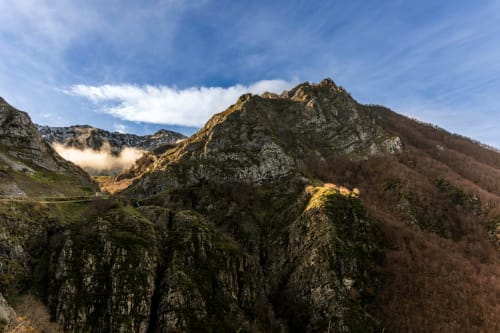 Picos rocosos cerca de Cofiñal con laderas boscosas y valles brumosos en la Cordillera Leonesa
