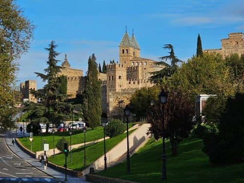 Castillo medieval con almenas y muros de piedra rodeado de jardines verdes en Cofiñal, España