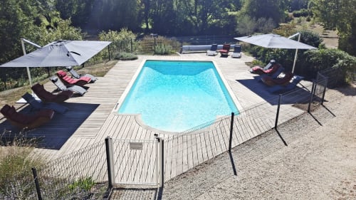 Zone de piscine luxueuse aux Gîtes Le Pech avec transats, parasols et vue sur la forêt à Sainte-Foy-de-Longas