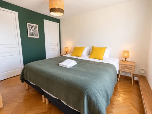 Chambre Maison Héléna du gîte hellofamily à Lain avec lit queen-size, accents verts et oreillers jaunes