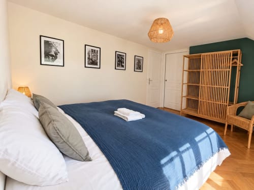Chambre spacieuse de la Maison Héléna à Lain avec lit queen-size, étagères en bois et décoration moderne