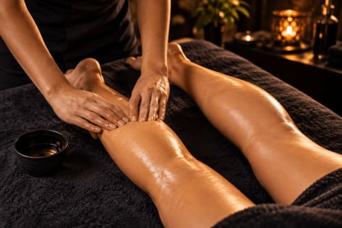 Massage therapist applying oil to client's leg at Jardin Sakina spa in Marrakech