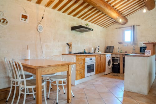 Cuisine spacieuse du Gîte Sous les Étoiles avec poutres en bois, table à manger et appareils modernes