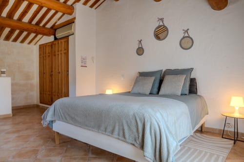 Chambre spacieuse dans le gîte Au Coin du Feu aux gîtes de Val avec lit queen-size, poutres en bois, vue sur le jardin et ambiance chaleureuse
