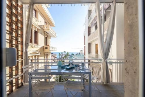 Balcone Seven Suites Sanremo con vista sul mare, elegante zona pranzo all'aperto affacciata sulla costa mediterranea
