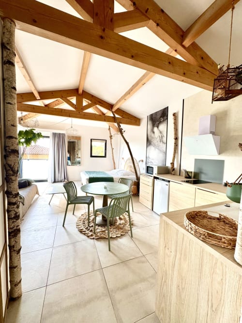 Modern open-plan suite at Maison Florence Ivakno with exposed wooden beams, kitchen, dining area and bedroom with hammam