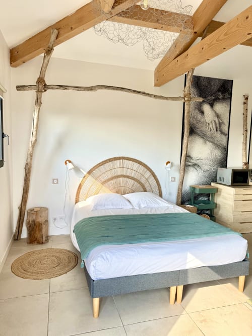 Luxury suite bedroom at Maison Florence Ivakno in Coudoux with woven headboard, green throw, exposed beams, and rustic décor