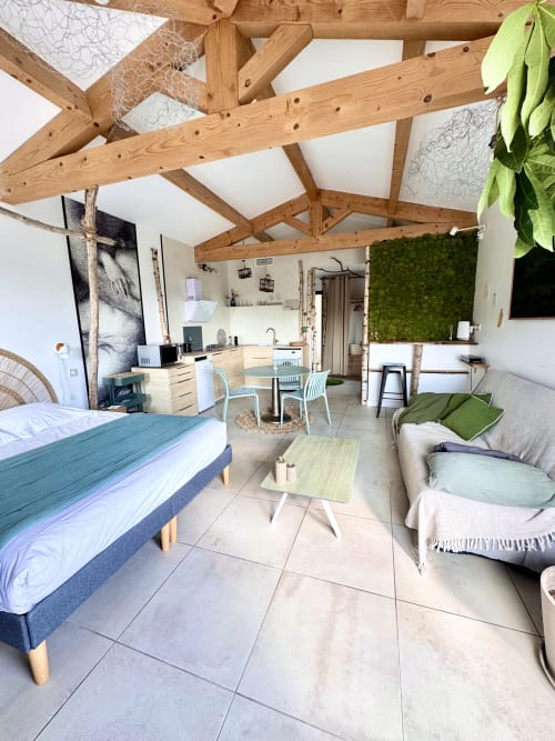 Spacious luxury suite at Maison Florence in Coudoux with wooden beams, kitchenette, bed, sofa, and modern amenities