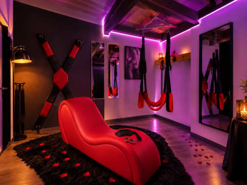 Chambre moderne avec méridienne rouge, éclairage néon violet et décoration intime aux Villas Aux Portes De L'océan
