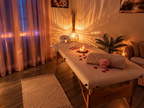Salle spa luxueuse aux Villas Aux Portes De L'océan avec tables de massage, éclairage ambiant, bougies et plantes tropicales